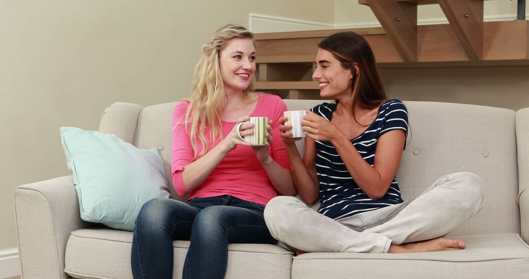 Two Happy Women Enjoying Coffee Together on Sofa at Home - Free Images, Stock Photos and Pictures on Pikwizard.com