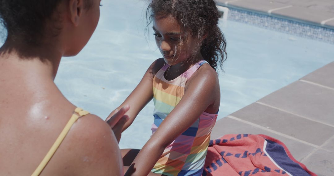 Mother Applying Sunscreen to Daughter by Poolside on Sunny Day - Free Images, Stock Photos and Pictures on Pikwizard.com