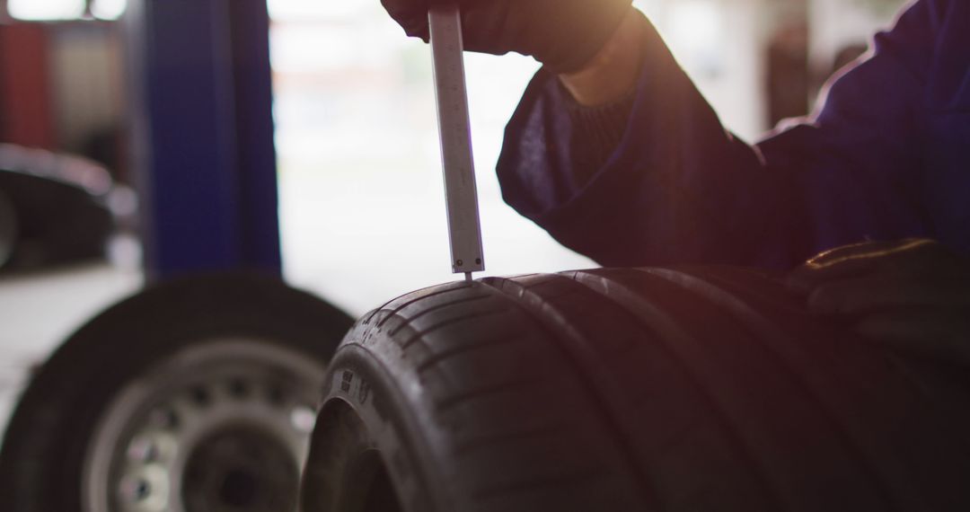 Mechanic Measuring Tire Tread Depth in Garage - Free Images, Stock Photos and Pictures on Pikwizard.com