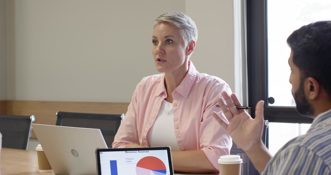 Business Colleagues Discussing Revenue Sources in Modern Workspace