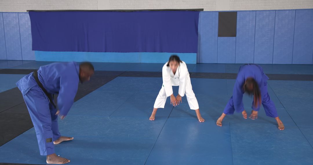 Martial Arts Students Stretching on Mats in Uniforms Highlighting Disciplinary Practice
