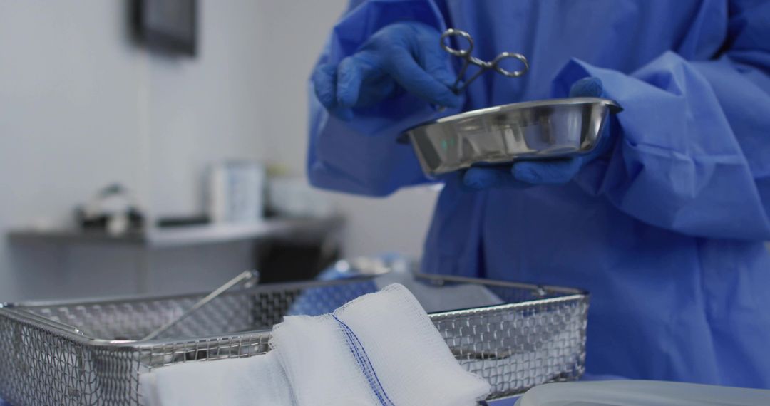 Surgical technician preparing sterile instruments with kidney dish, forceps and gauze