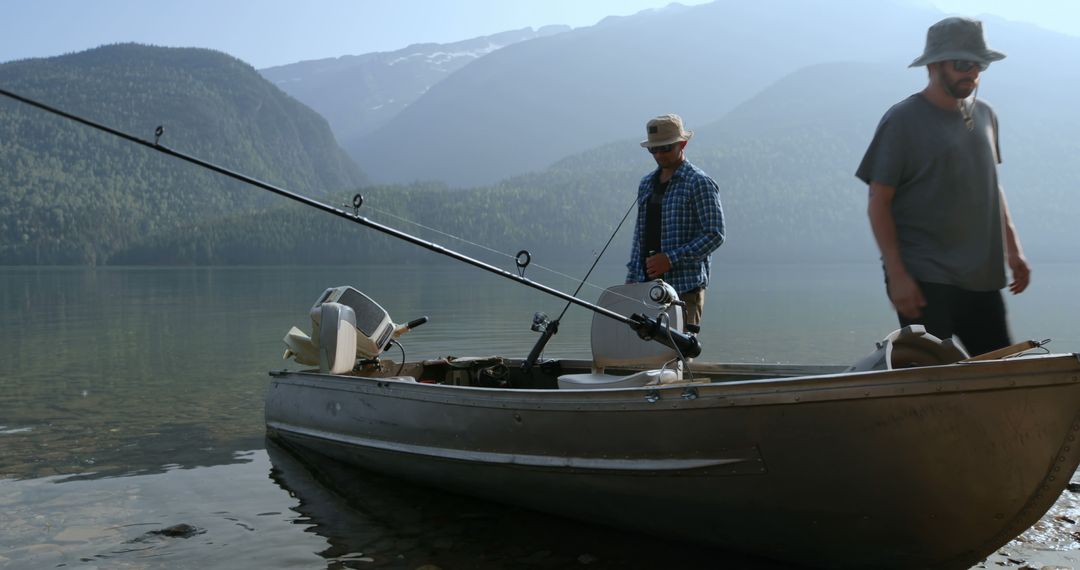 Two Men Preparing to Fish on Serene Lake in Mountains - Free Images, Stock Photos and Pictures on Pikwizard.com