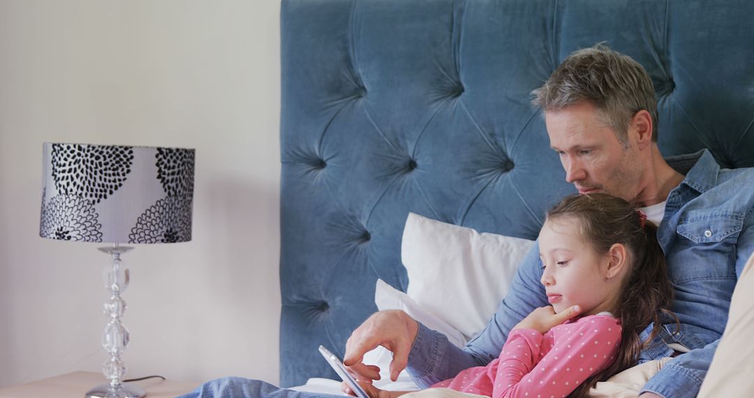 Father and Daughter Reading Tablet Together on Bed - Free Images, Stock Photos and Pictures on Pikwizard.com