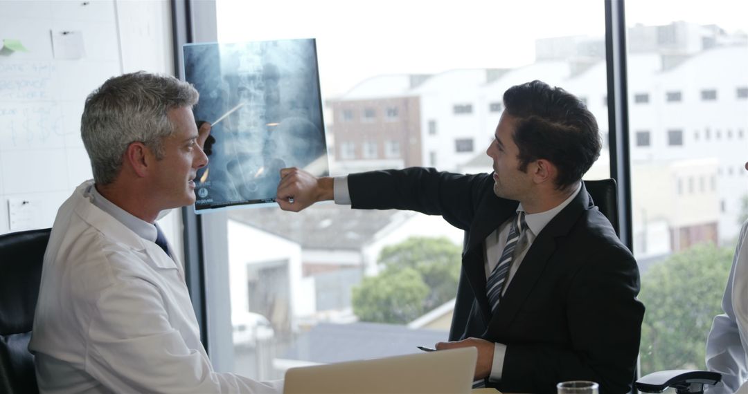 Doctor and Businessman Discussing X-Ray Results in Modern Office - Free Images, Stock Photos and Pictures on Pikwizard.com