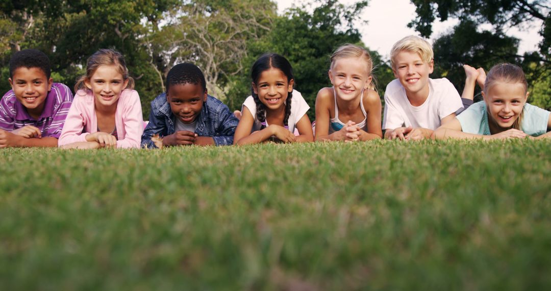 Group of Smiling Children Lying on Grass Outdoors - Free Images, Stock Photos and Pictures on Pikwizard.com