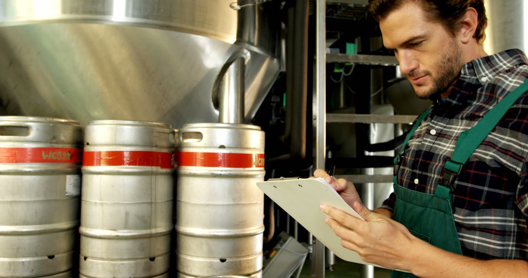 Brewery Worker Checking Inventory in Brewery Facility - Free Images, Stock Photos and Pictures on Pikwizard.com