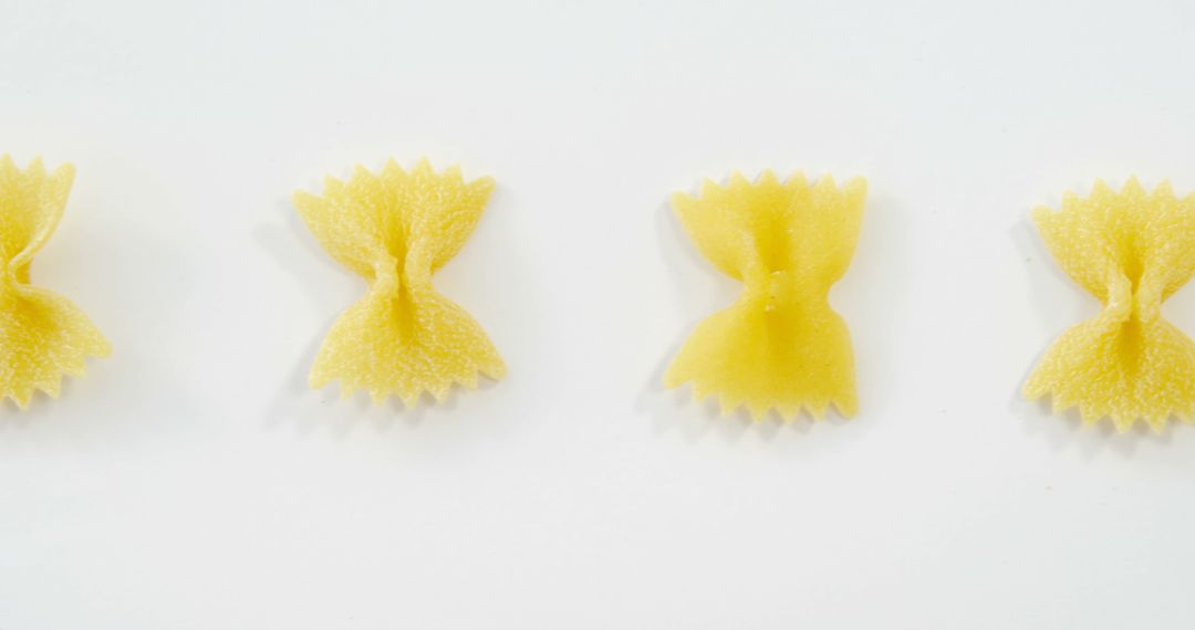 Bowtie Pasta Arranged in a Row on White Background - Free Images, Stock Photos and Pictures on Pikwizard.com