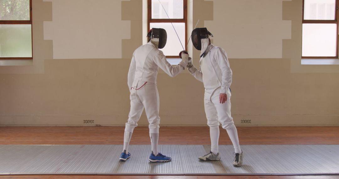 Two Fencers Engaging in Fencing Match Indoors - Free Images, Stock Photos and Pictures on Pikwizard.com