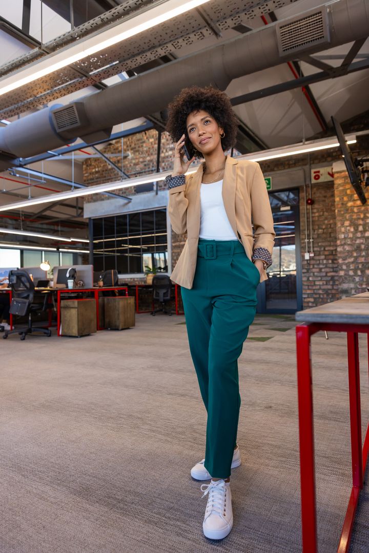 Confident Businesswoman Conversing on Smartphone in Modern Open Office
