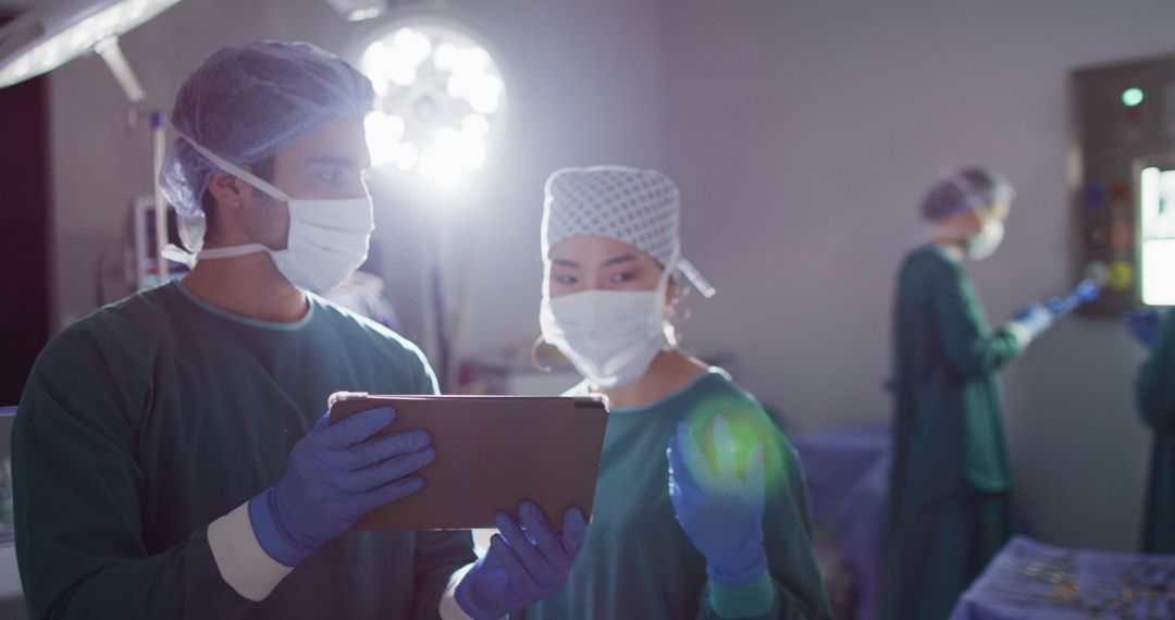 Medical Team Analyzing Patient Data on Digital Tablet in Operating Room - Free Images, Stock Photos and Pictures on Pikwizard.com