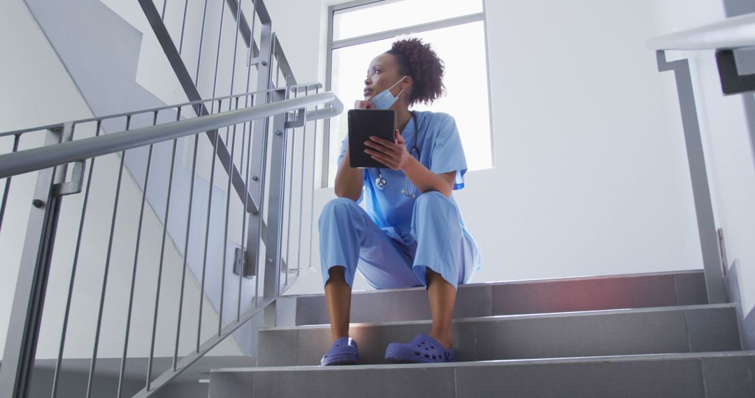 Nurse Taking a Break on Stairway Holding Clipboard - Free Images, Stock Photos and Pictures on Pikwizard.com