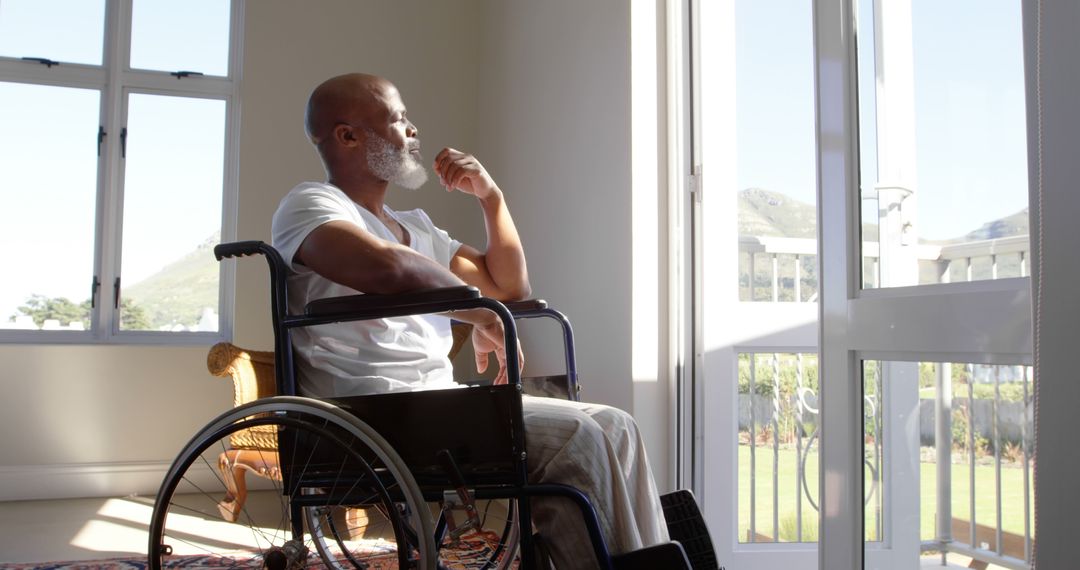 Contemplative Man in Wheelchair Gazing Out Sunny Window - Free Images, Stock Photos and Pictures on Pikwizard.com