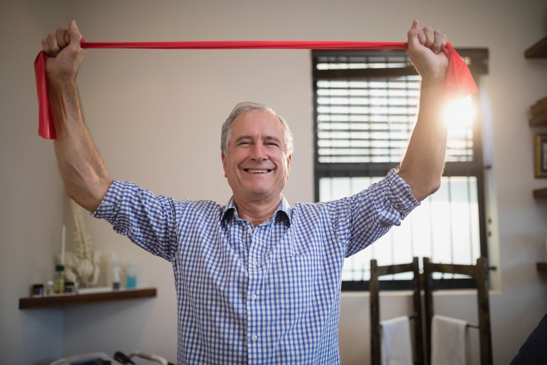 Smiling Senior Man Holding Red Resistance Band in Hospital Ward - Free Images, Stock Photos and Pictures on Pikwizard.com