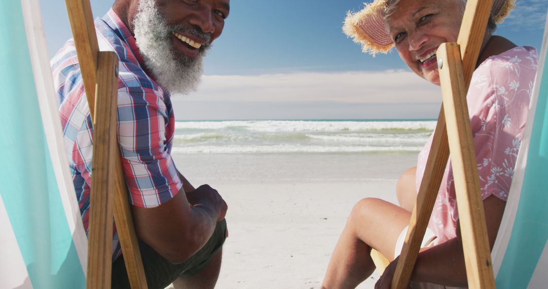 Senior Couple Enjoying Relaxation on Sunny Beach Chairs