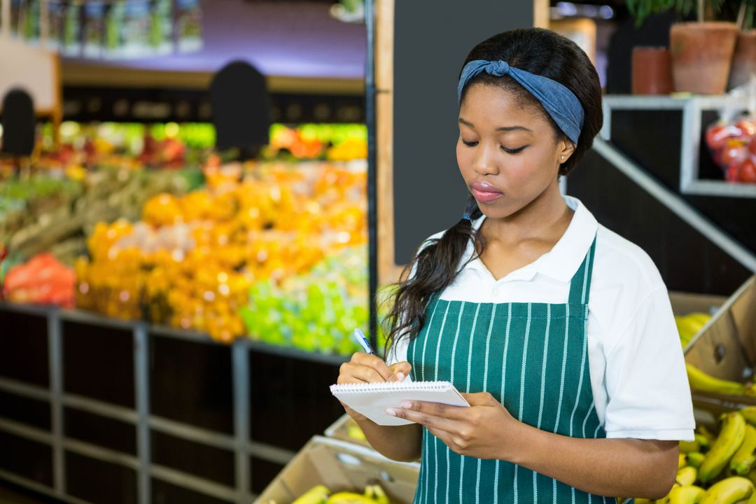 Female Grocery Worker Taking Inventory in Produce Section