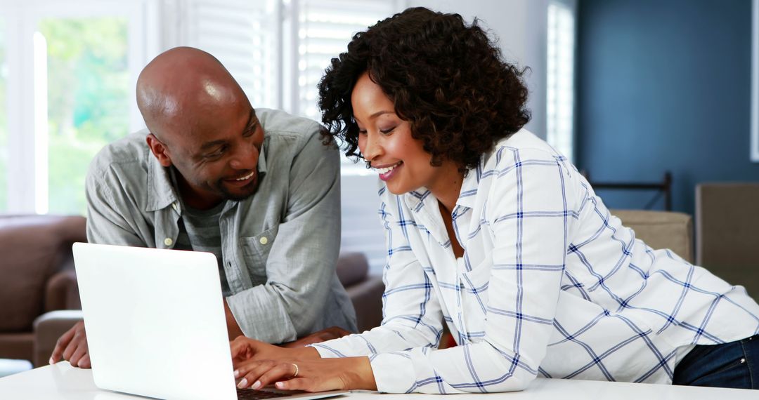 Couple Smiling and Browsing Laptop Together