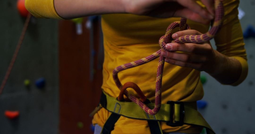 Caucasian woman tying protective rope by climbing wall - Free Images, Stock Photos and Pictures on Pikwizard.com