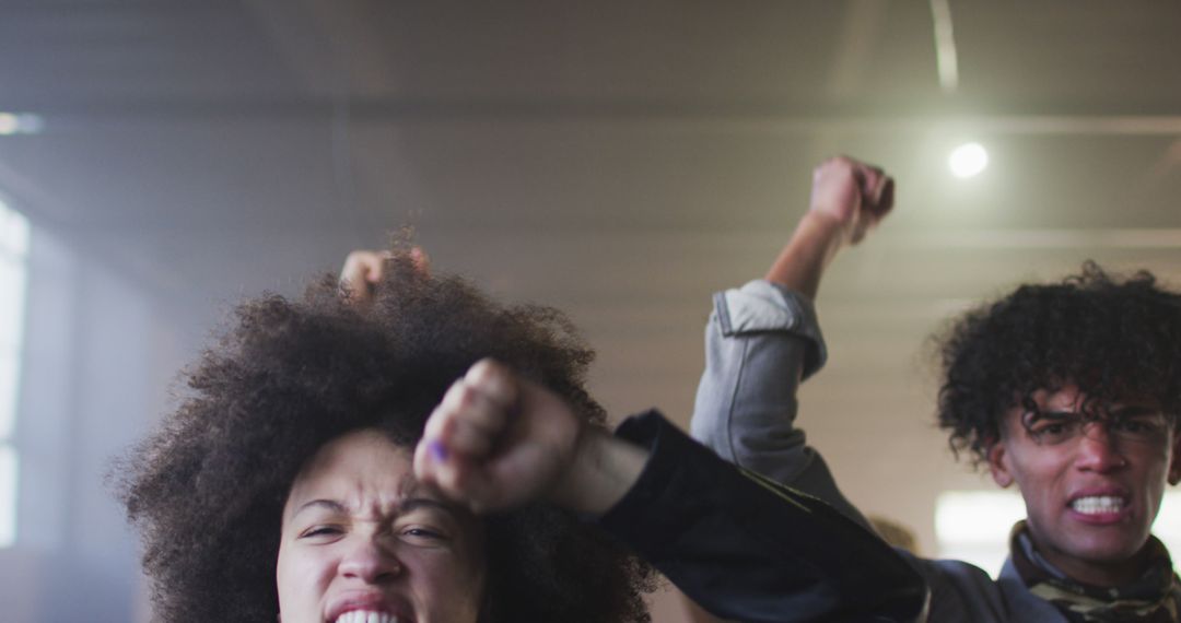 Passionate Protesters Demonstrating with Raised Fists in Warehouse - Free Images, Stock Photos and Pictures on Pikwizard.com