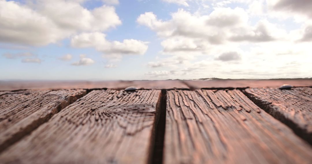 Rustic Wooden Plank Overlook with Cloudy Sky and Flying Bird