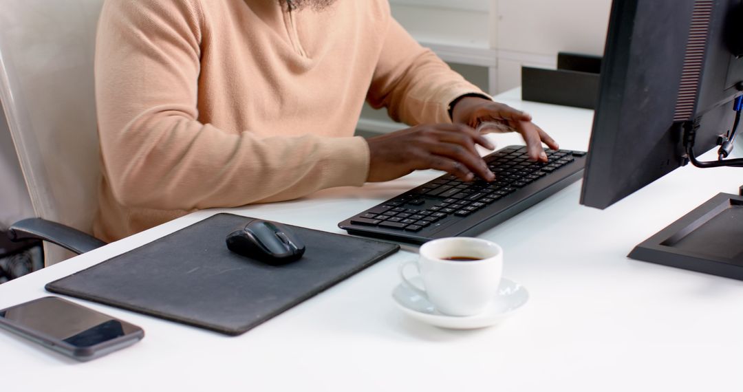 Man Working at Desk with Computer and Coffee in Professional Office Environment