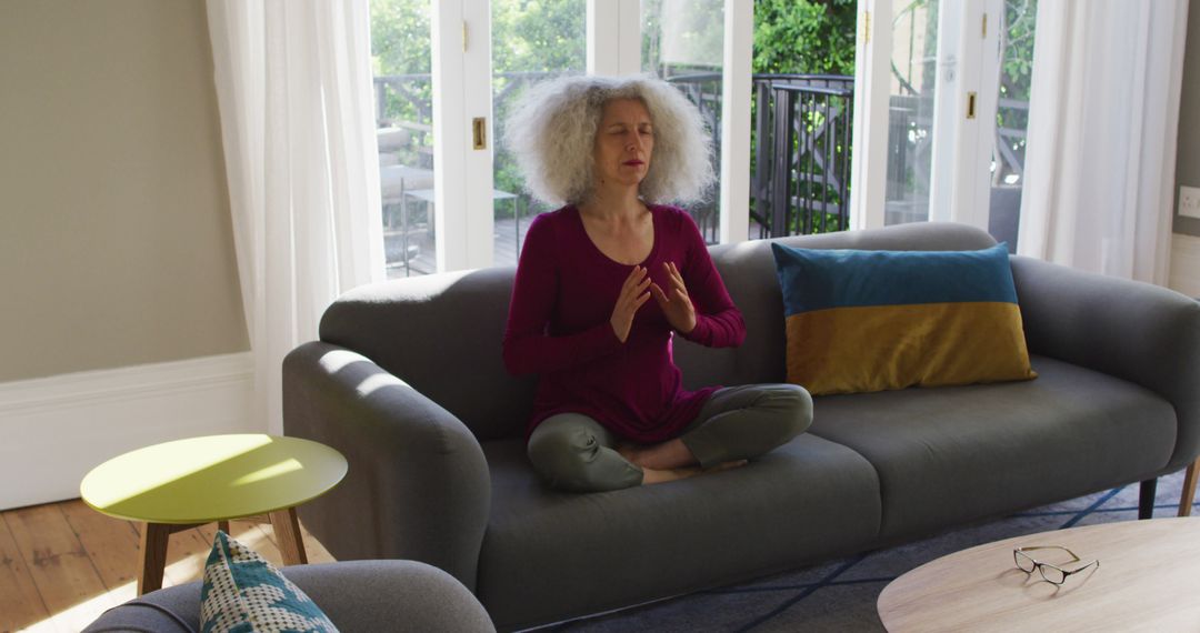 Senior Woman Meditating in Living Room with Large Windows - Free Images, Stock Photos and Pictures on Pikwizard.com