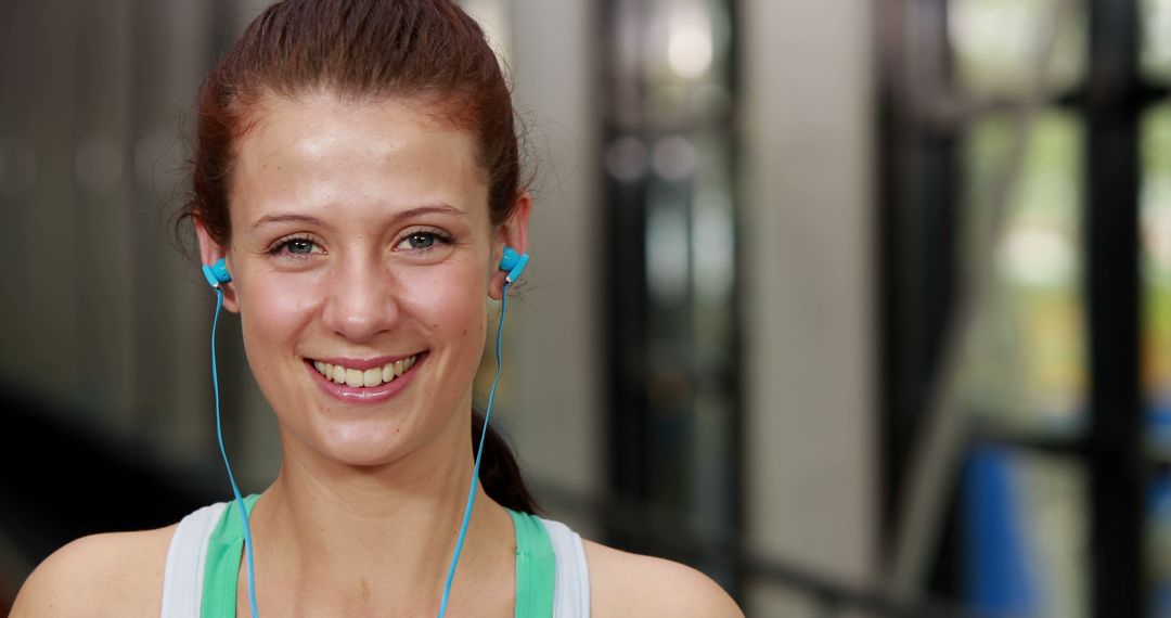 Happy Woman with Headphones Exercising Indoors - Free Images, Stock Photos and Pictures on Pikwizard.com