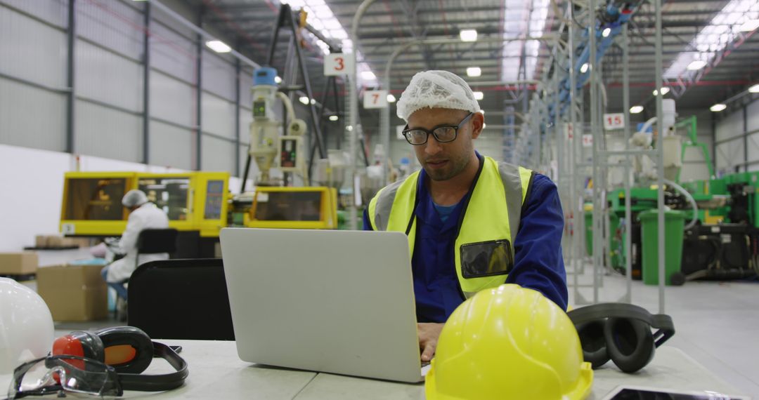 Factory Worker Using Laptop in Industrial Setting - Free Images, Stock Photos and Pictures on Pikwizard.com