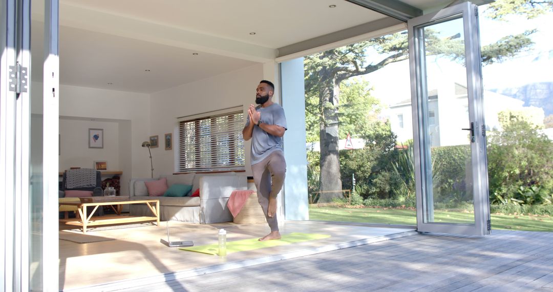 Man Practicing Yoga at Home in Bright Open Space - Free Images, Stock Photos and Pictures on Pikwizard.com