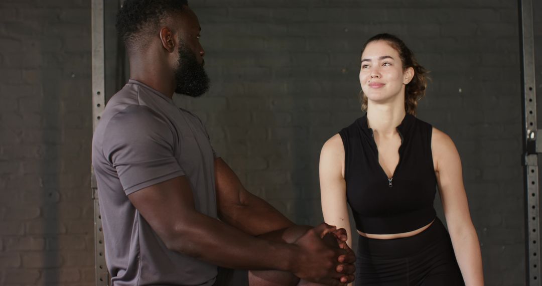 Personal Trainer Demonstrates Quadriceps Stretch in Gym
