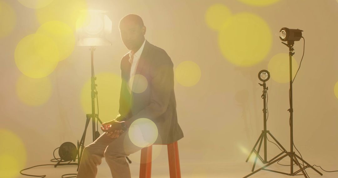 Model Wearing Gray Blazer Posing on Red Stool in Studio Lighting