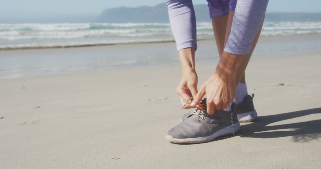 Woman Tying Running Shoes on Beach Shore - Free Images, Stock Photos and Pictures on Pikwizard.com