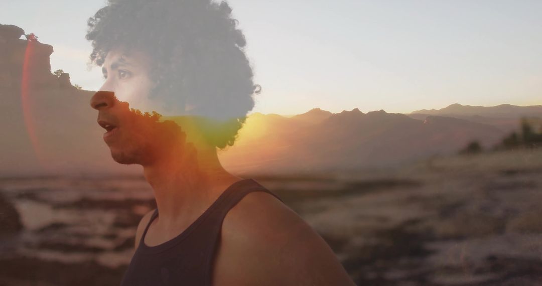 Contemplative Man Gazes at Sunset Seascape on Rocky Shoreline with Lens Flare