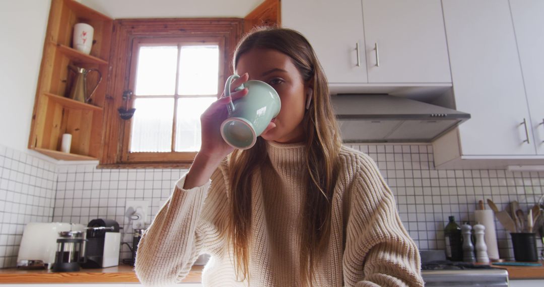 Young Woman Drinking Coffee in Cozy Home Kitchen - Free Images, Stock Photos and Pictures on Pikwizard.com