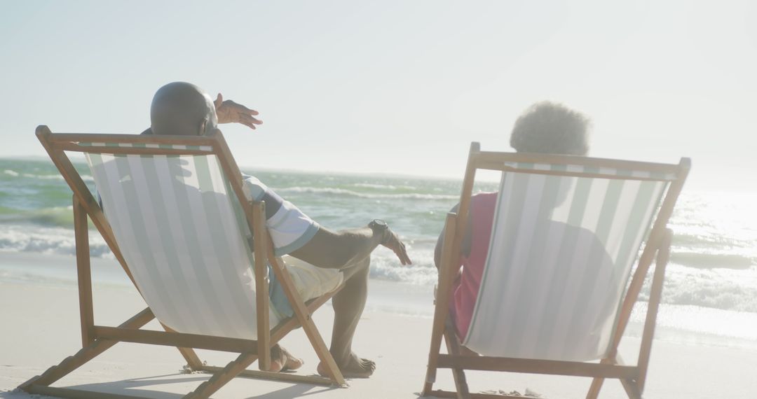 Senior African American Couple Relaxing on Beach Chairs at Seaside - Free Images, Stock Photos and Pictures on Pikwizard.com