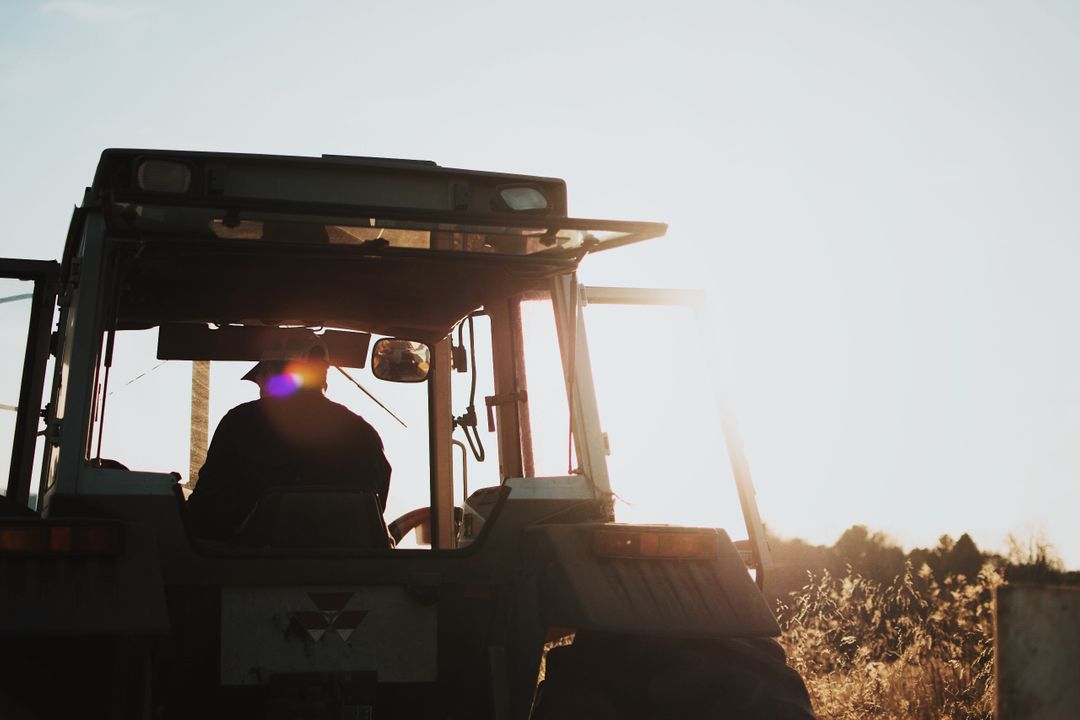 Farmer Driving Tractor During Sunset on Countryside Field - Free Images, Stock Photos and Pictures on Pikwizard.com