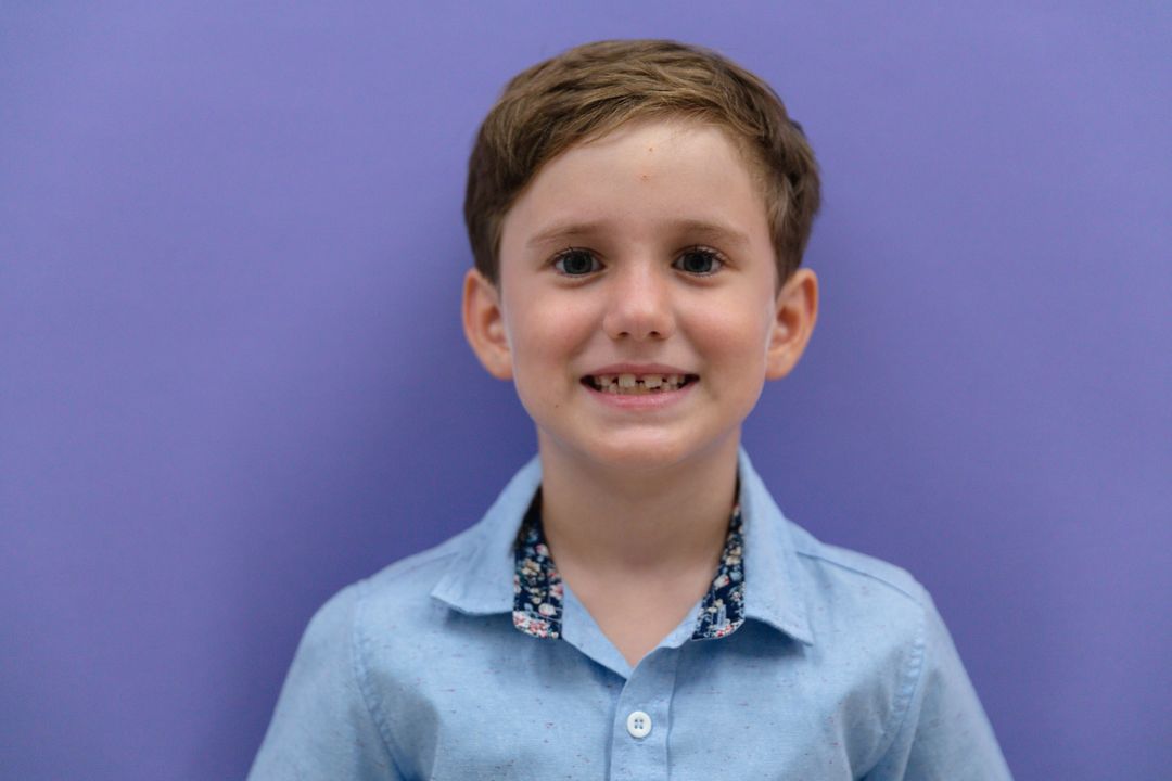 Portrait of smiling cute caucasian elementary schoolboy against purple background - Free Images, Stock Photos and Pictures on Pikwizard.com