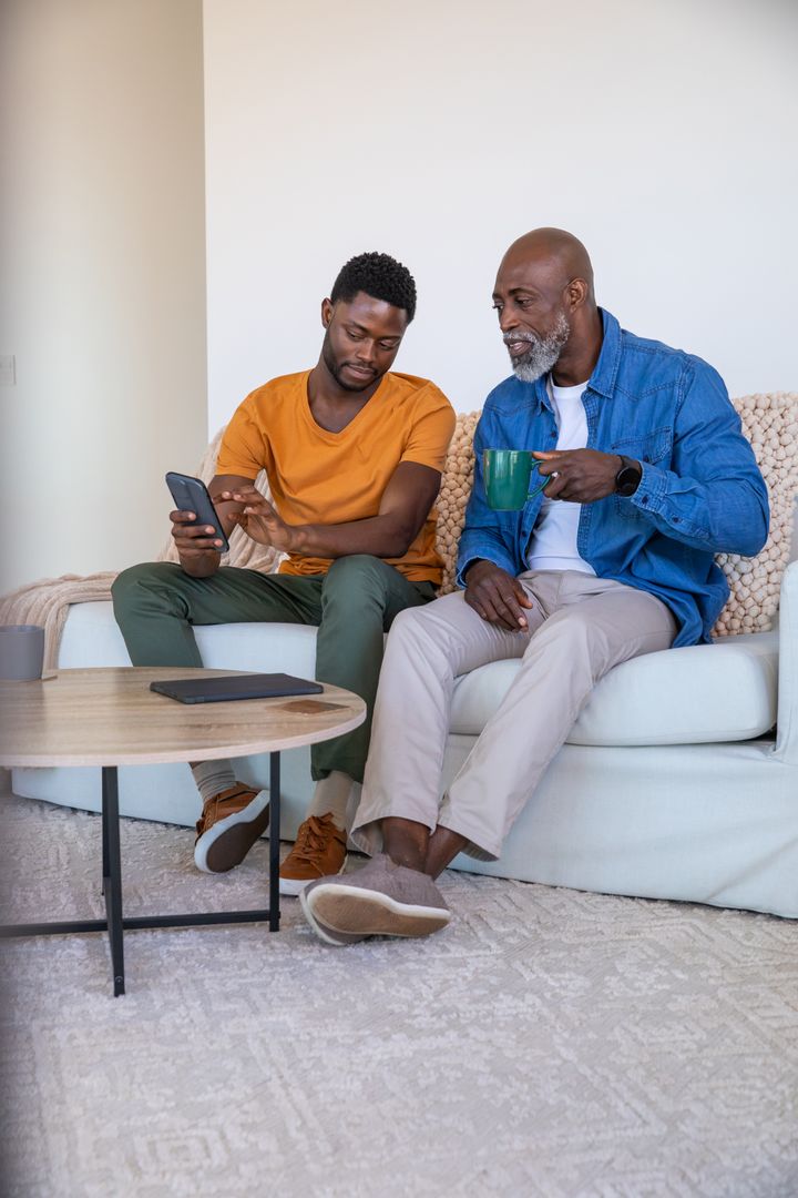 Father and Son Bonding at Home with Smartphone and Coffee