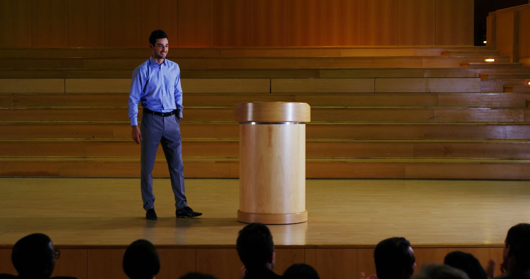Man Giving Presentation on Stage in Auditorium with Wooden Podium - Free Images, Stock Photos and Pictures on Pikwizard.com