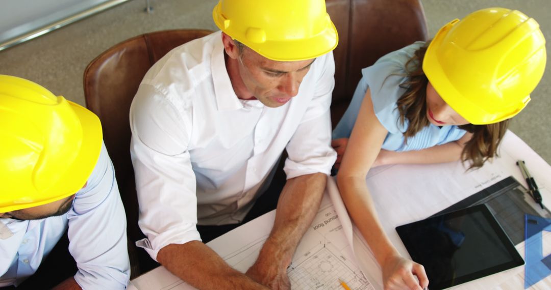 Architects in Team Collaboration Reviewing Blueprint in Office