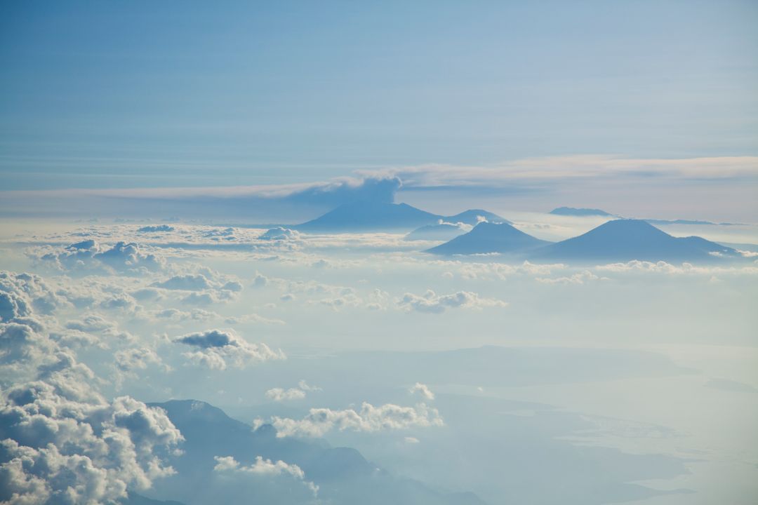 Aerial view of mountain peaks rising above cloud layer at dawn - Free Images, Stock Photos and Pictures on Pikwizard.com
