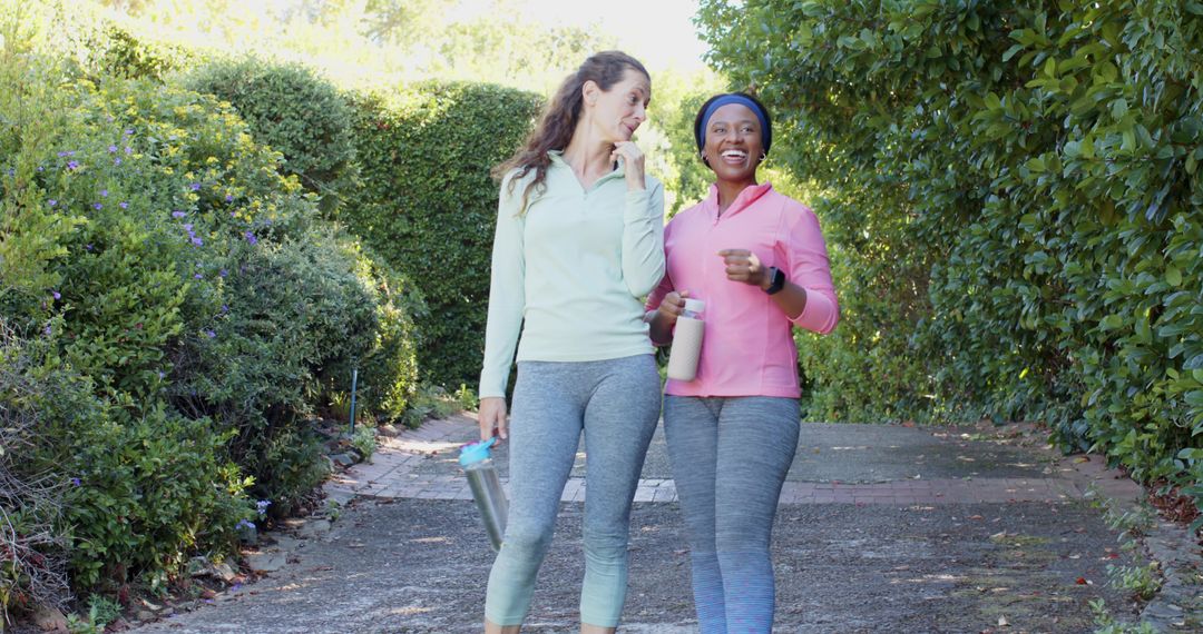 Diverse Female Friends Exercising with Bottles in Lush Park