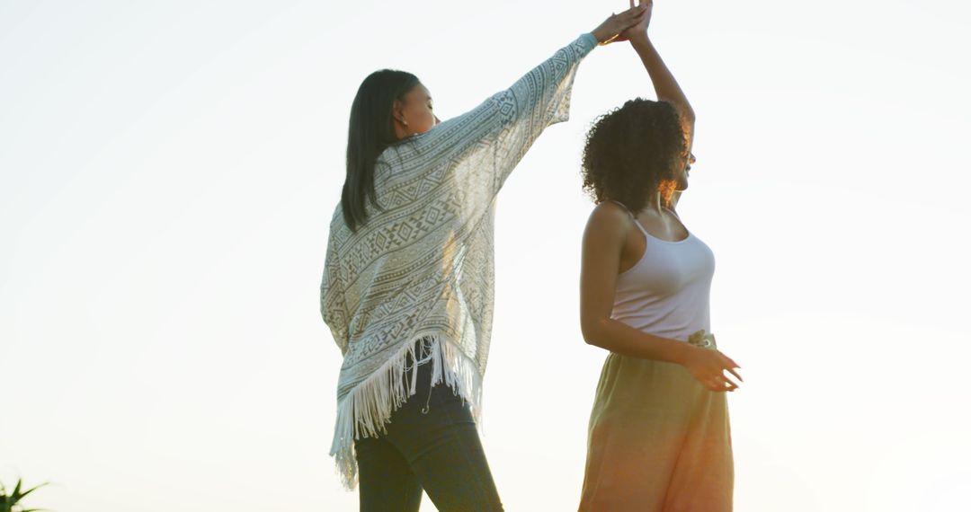 Two women dancing outdoors at sunset enjoying life - Free Images, Stock Photos and Pictures on Pikwizard.com