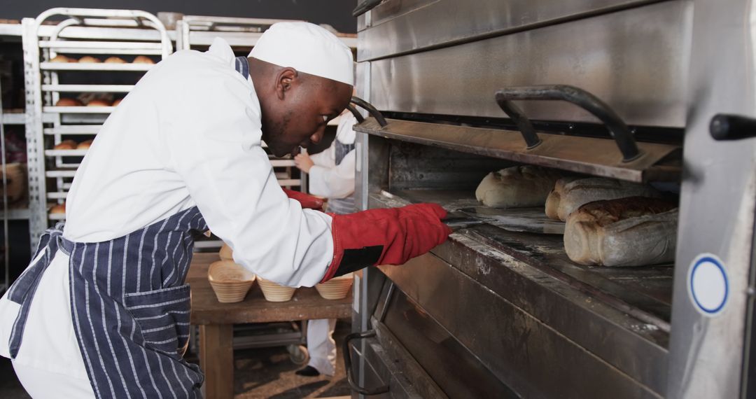 Male Baker Removing Freshly Baked Bread from Oven in Bakery - Free Images, Stock Photos and Pictures on Pikwizard.com