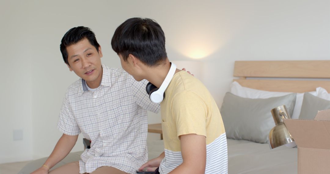 Father and Son Sharing a Joyful Moment Unboxing in Bedroom