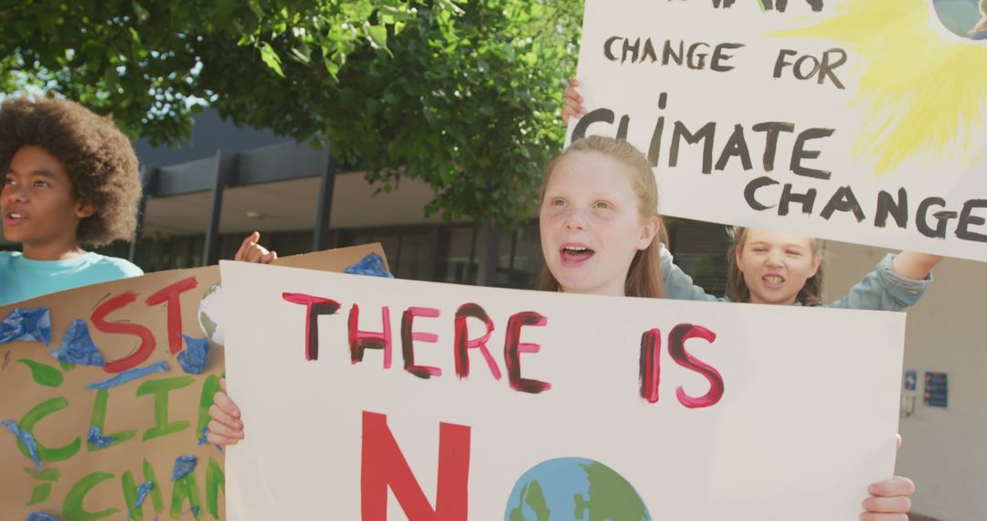 Young Activists Holding Protest Signs for Climate Change Awareness Outdoors - Free Images, Stock Photos and Pictures on Pikwizard.com