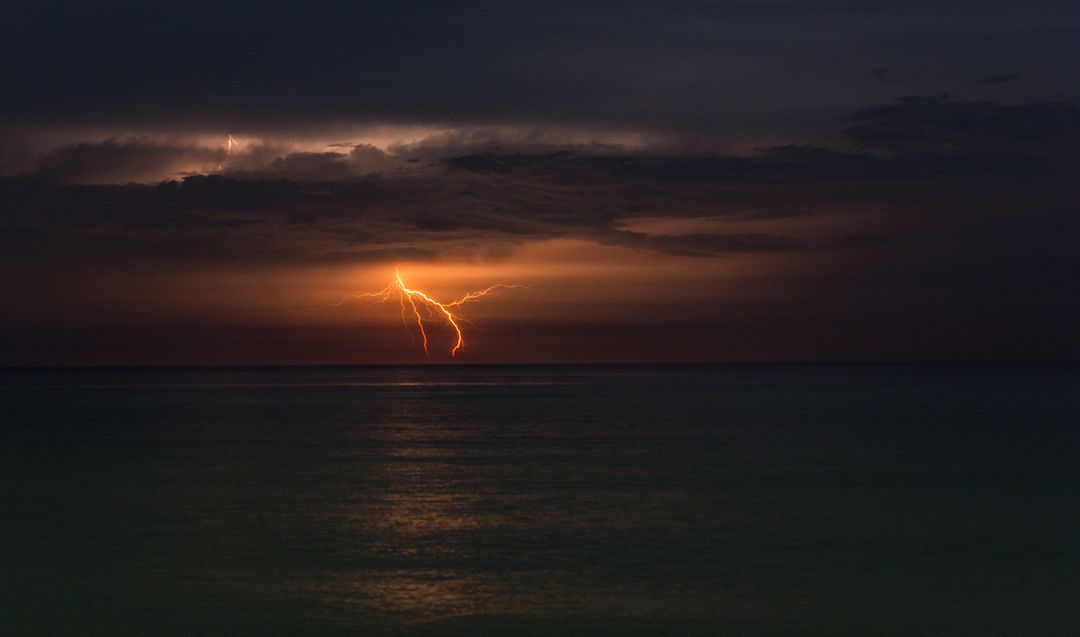 Dramatic Lightning Strike Over Calm Ocean at Night - Free Images, Stock Photos and Pictures on Pikwizard.com