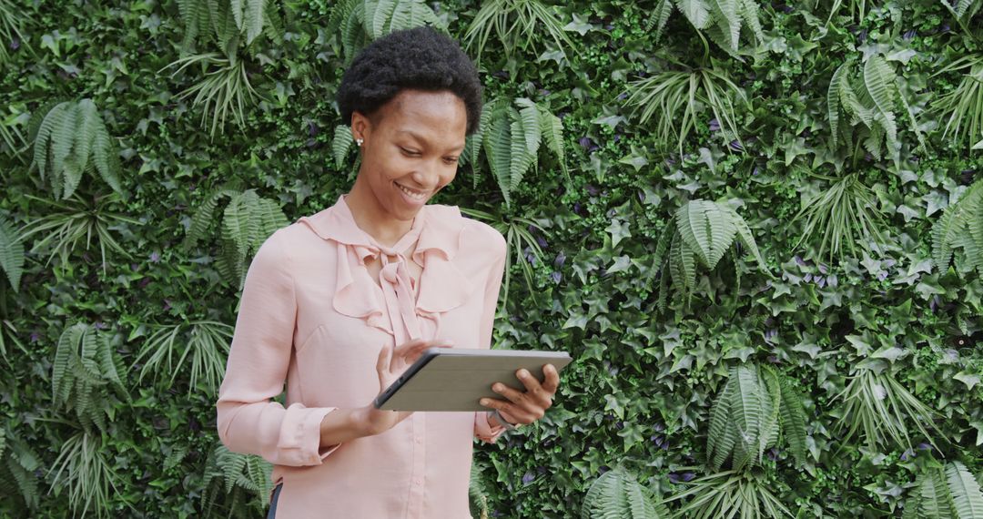 Smiling Woman Using Digital Tablet Against Greenery Backdrop - Free Images, Stock Photos and Pictures on Pikwizard.com