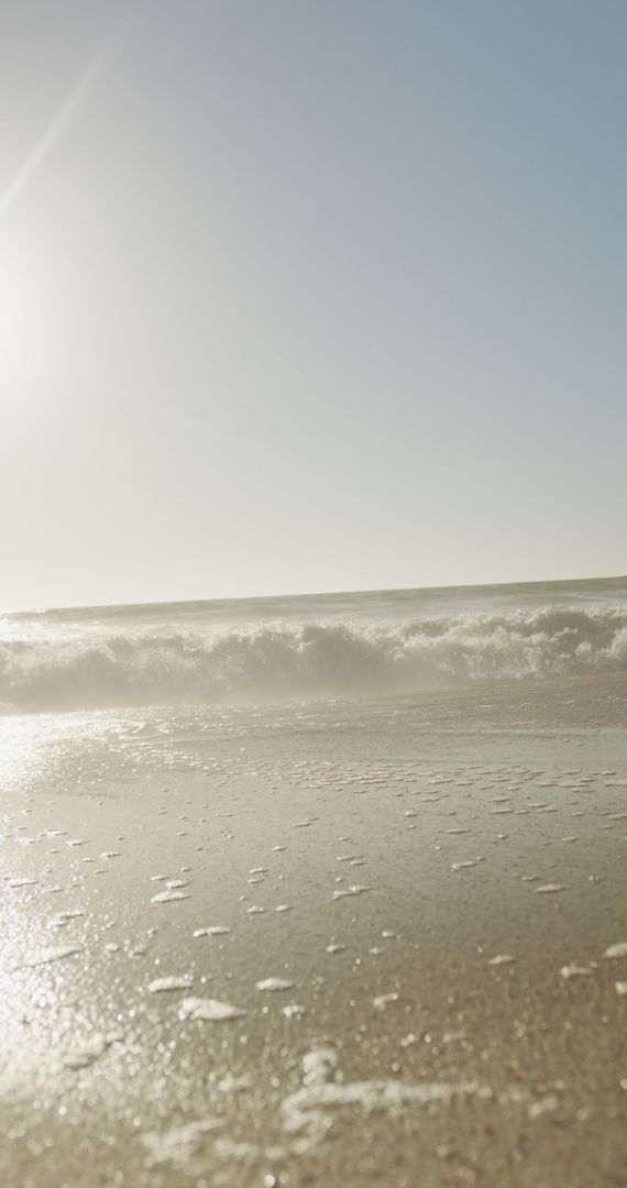 Tranquil Seashore with Gentle Waves Under Bright Sunlight
