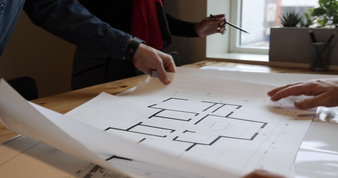 Architects Collaborating Over Building Plans in Office